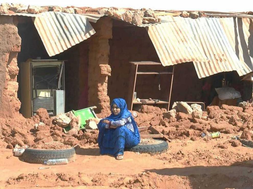 Un mujer sentada junto a los escombros provocados por las lluvias en un campo saharau