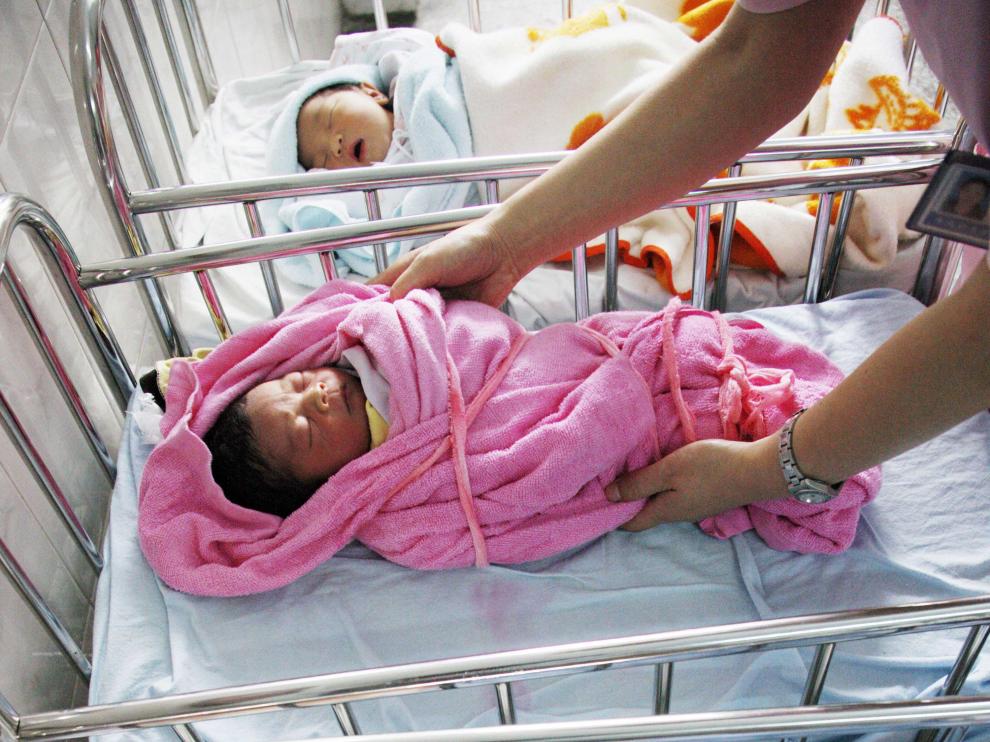 Una enfermera china atiende a dos bebés.