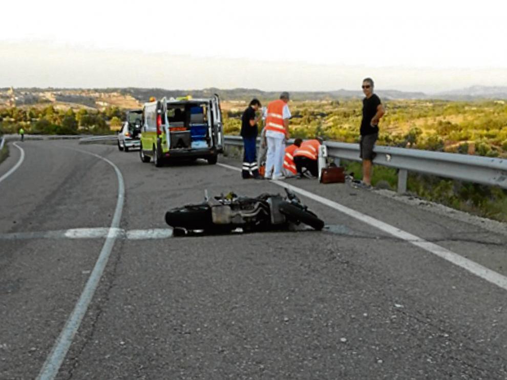Los sanitarios intentan reanimar al motorista tendido en la carretera A-1413 cerca de Cretas.