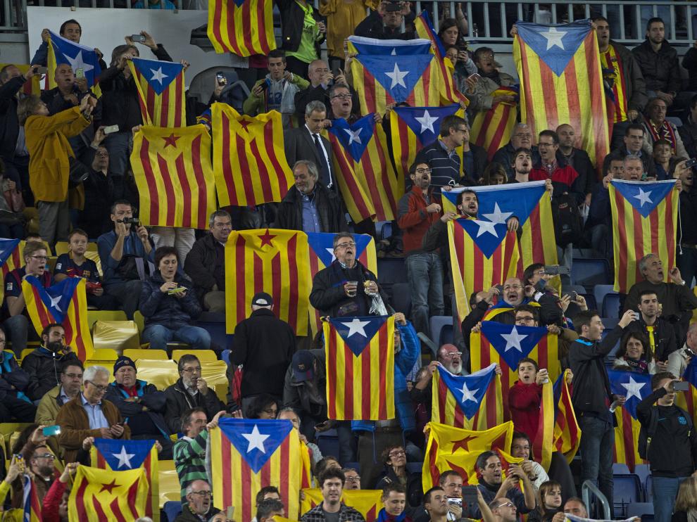 Decenas de voluntarios reparten esteladas a las puertas del Camp Nou