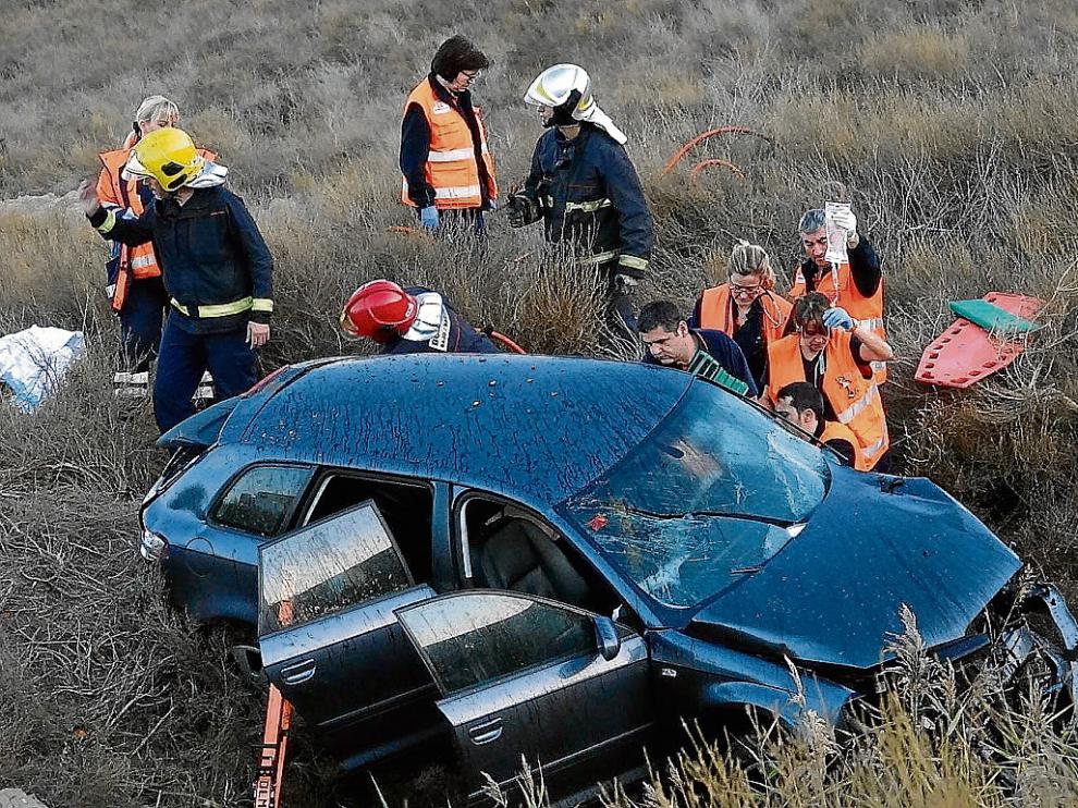 Los sanitarios asisten al único de los tres ocupantes del turismo que salió con vida.