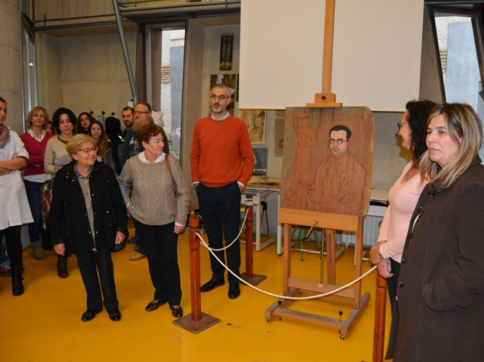Ana y Katy García-Bragado, junto a Ignacio Bustienes, miran la pintura realizada por su abuelo en 1928 y ya restaurada-