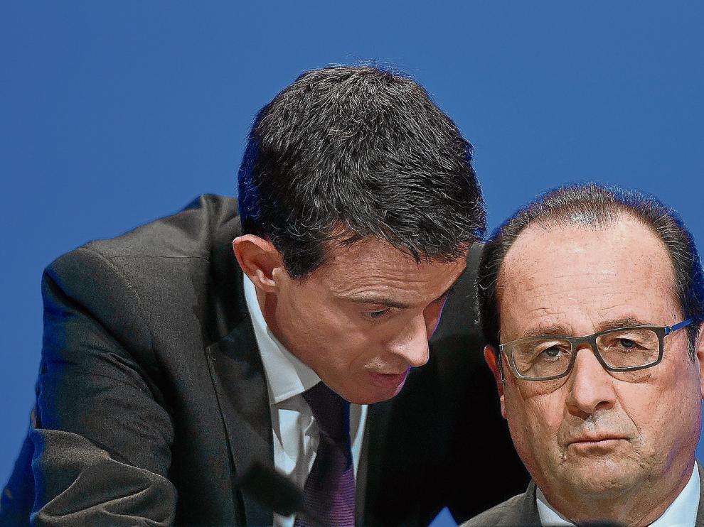 François Hollande escucha atentamente al primer ministro francés, Manuel Valls.