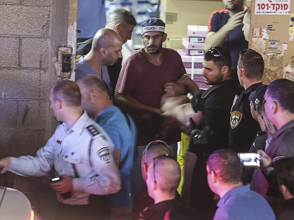 Agentes de policía detienen a un palestino en el lugar del ataque perpetrado en Tel Aviv.