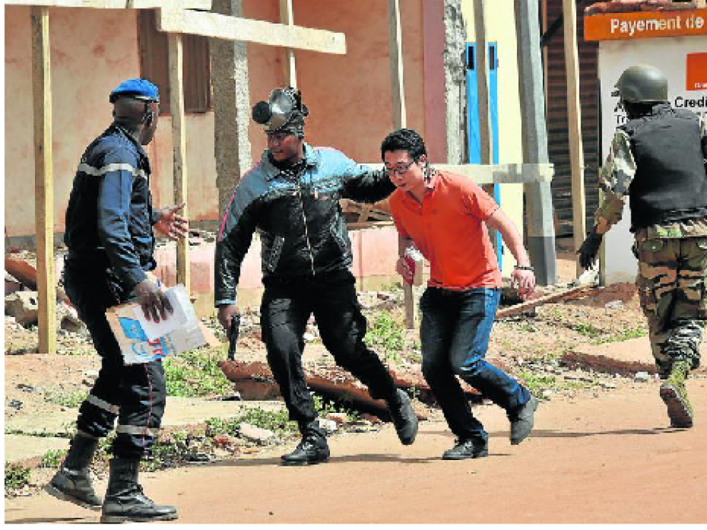 Agentes de la Policía de Mali evacuan a un hombre de los alrededores del hotel Blu Radisson de Bamako.