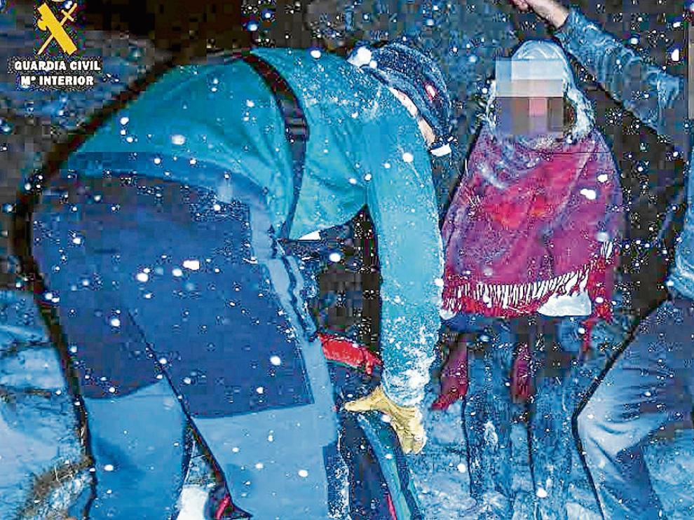 Uno de los agentes del Greim con los dos montañeros enriscados.