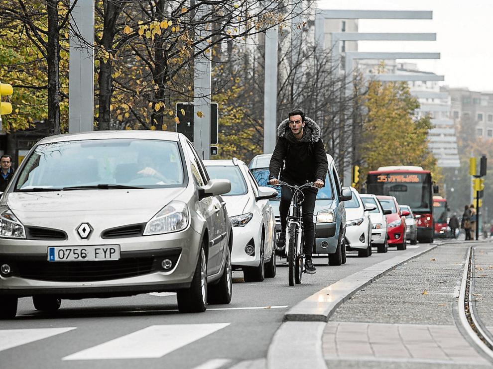 Un ciclista se hace hueco entre coches y buses en el paseo de la Independencia.