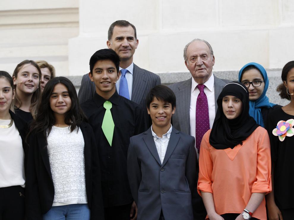 El Rey Felipe VI y el Rey Juan Carlos, posan con un grupo de estudiantes, a su llegada al Palacio de Cibeles de Madrid