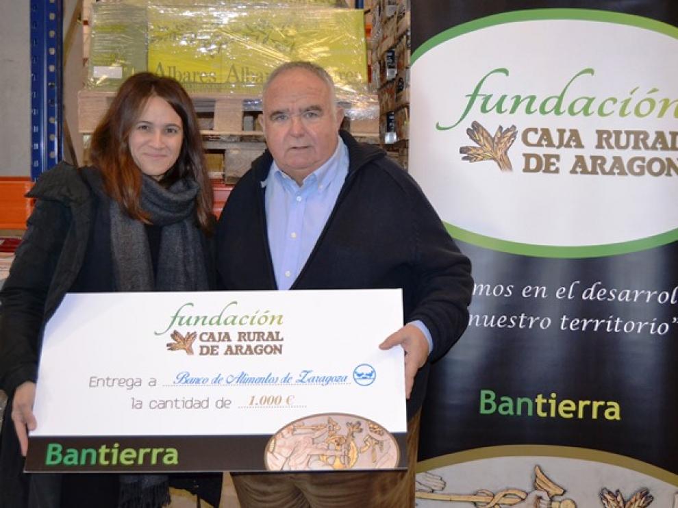 Jana Catalán, directora de la Fundación Caja Rural de Aragón en el momento de la entrega solidaria a José Ignacio Alfaro, presidente del Banco de Alimentos de Zaragoza.