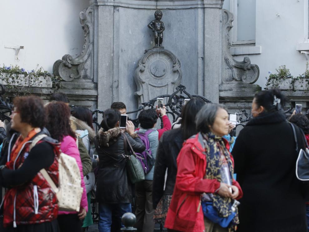 Varios turistas fotografían al Manekken Pis.