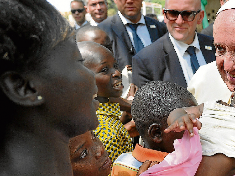 Francisco sonríe a una madre y su bebé, ayer en Bangui (República Centroafricana) .