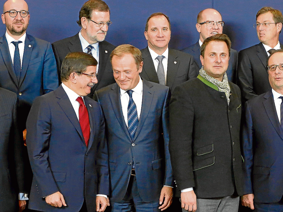 Abajo, el primer ministro turco, Ahmet Davutoglu, habla con Donald Tusk (Consejo Europeo), junto al luxemburgués Xavier Bettel y el francés François Hollande. Arriba, Mariano Rajoy.