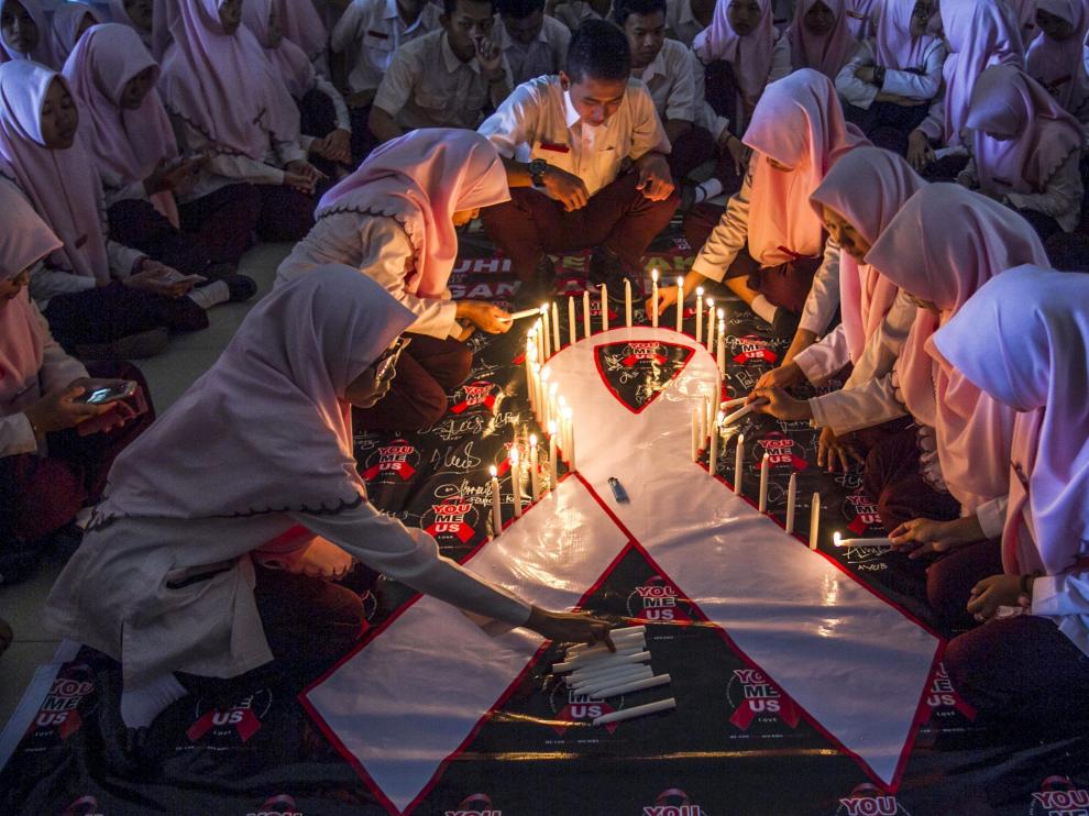 Estudiantes indonesios encienden velas durante un acto conmemorativo del Día Mundial de la lucha contra el sida.