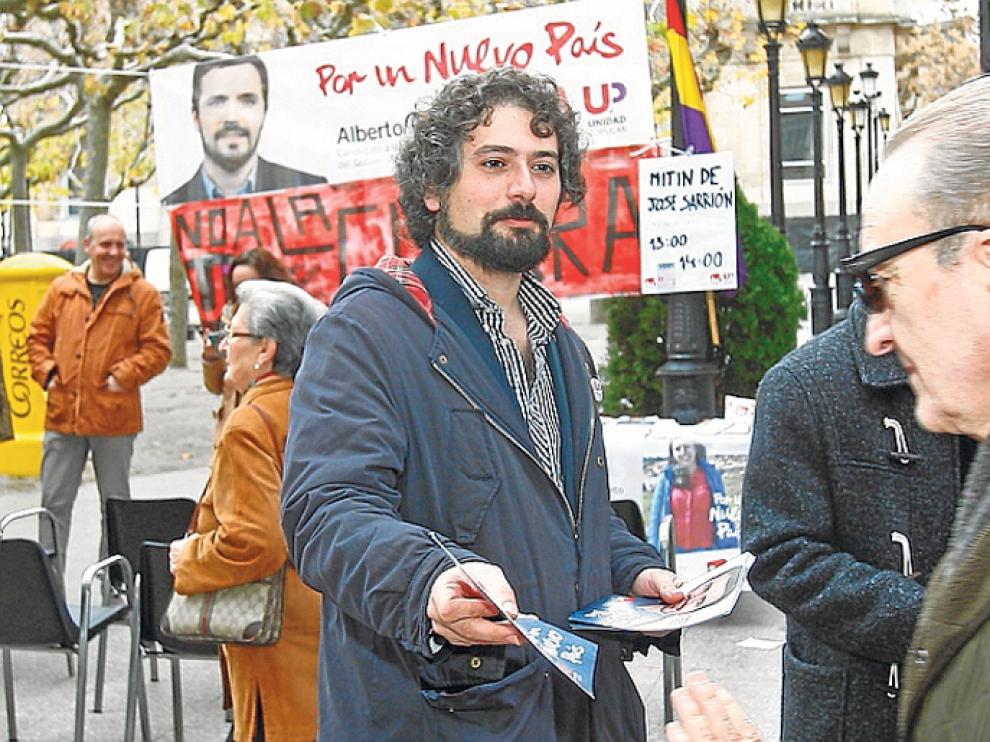 El procurador de Izquierda Unida en las Cortes de Castilla y León, José Sarrión, entrega folletos de IU en El Collado.