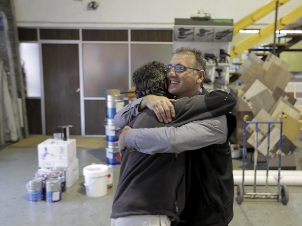 Alberto Gállego, empleado de Comercial Moré, abraza a Miguel Ángel Gracia, cliente.