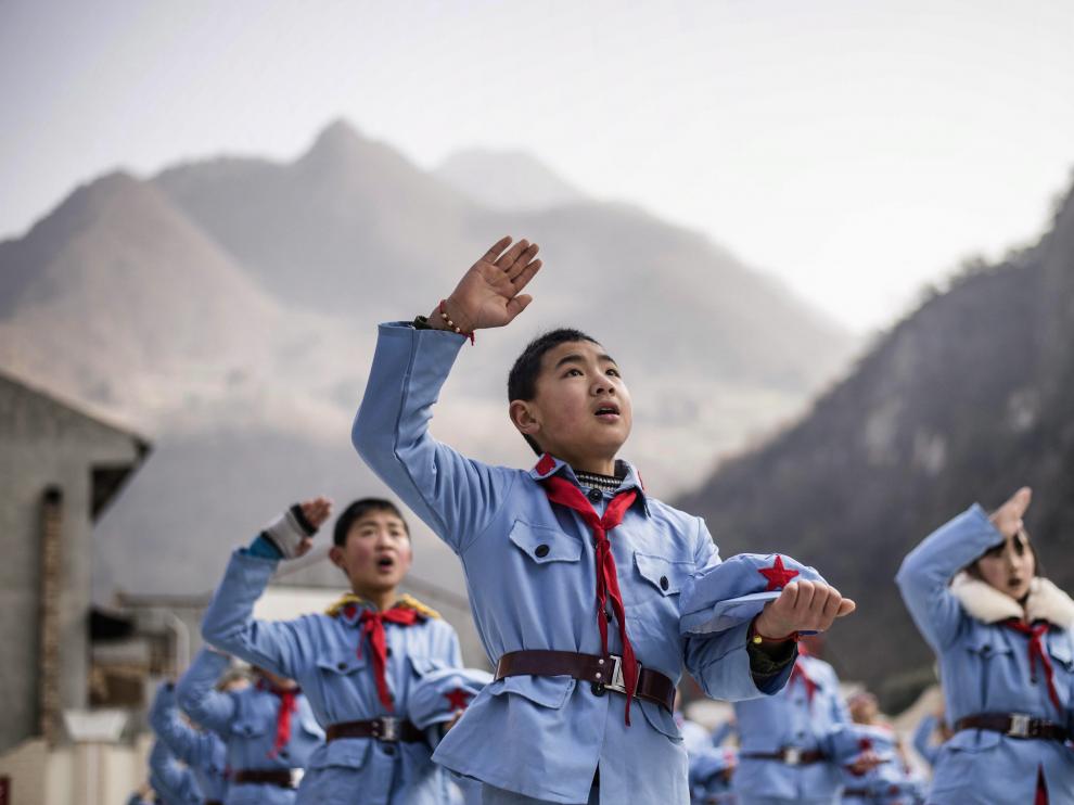 Un niño uniformado canta tras izar la bandera nacional en la escuela de primaria del Ejército Rojo de Beichuan, en la provincia de Sichuan, al suroeste de China. Fotografía tomada el 21 de enero de 2015