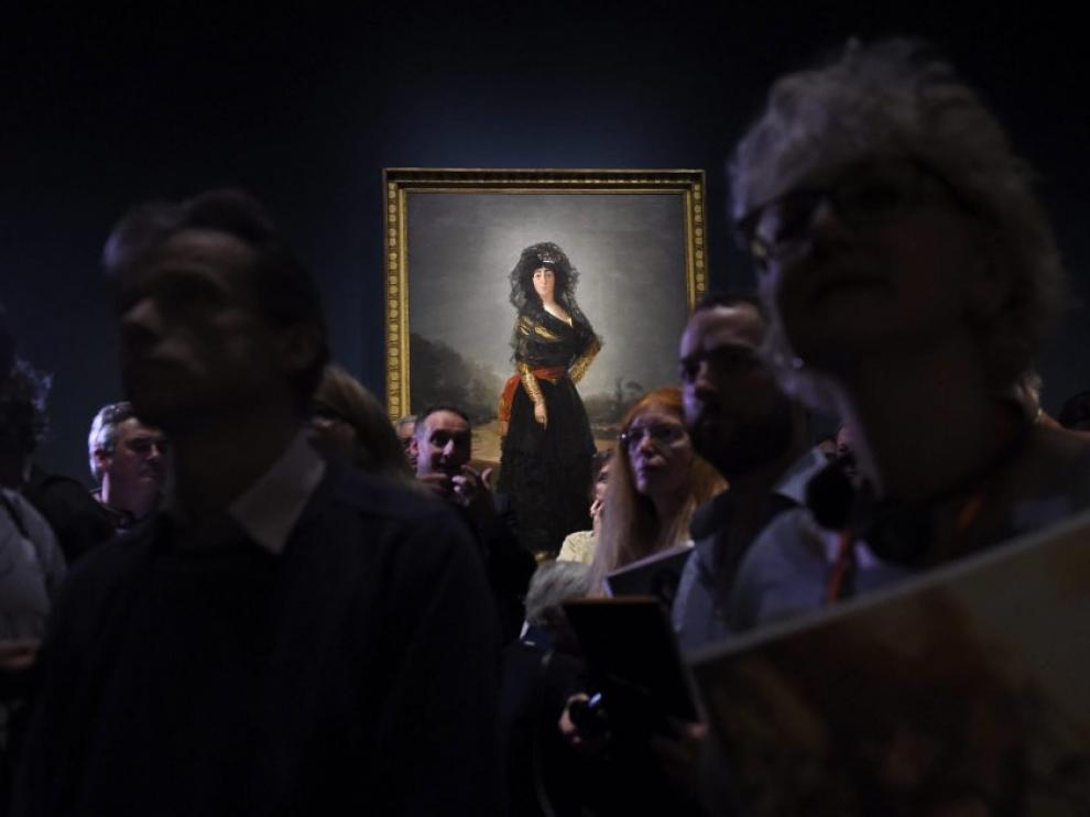 Visitantes de la exposición de retratos de Goya en la National Gallery de Londres, con el cuadro de la Duquesa de Alba de luto al fondo.