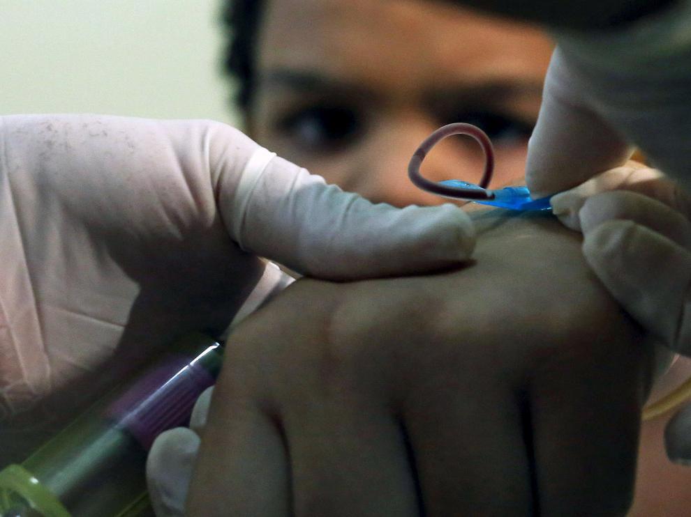 Un médico toma una muestra de sangre a un niño en Brasil para hacerle la prueba del virus zika.