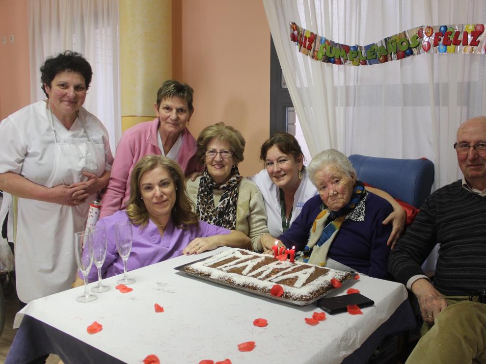 En el centro, María Val sopla las velas rodeada de familiares y trabajadoras de la residencia.