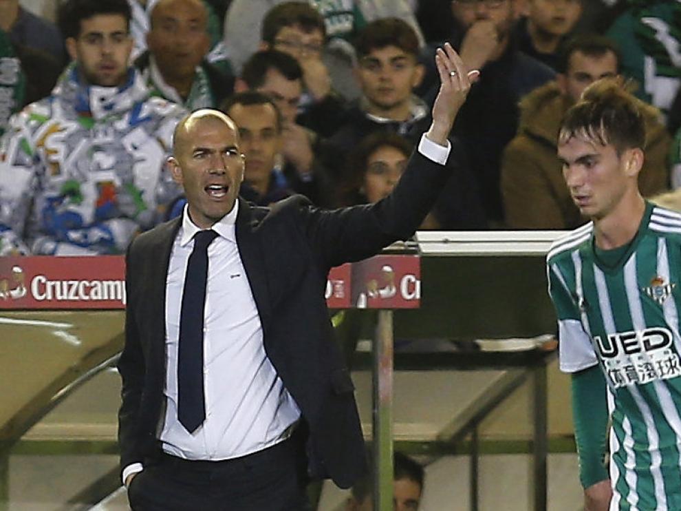 Zidane y un jugador del Betis durante el encuentro de este domingo.