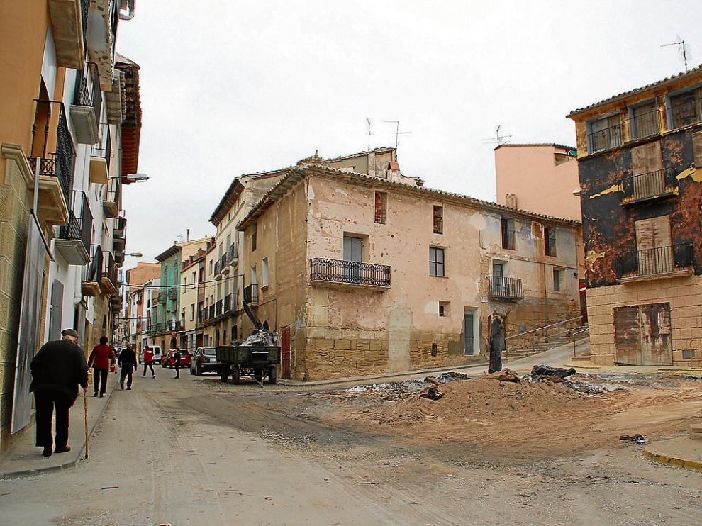 Los restos de la Hoguera permanecen en la plaza. A la derecha, la casa más dañada por las llamas.