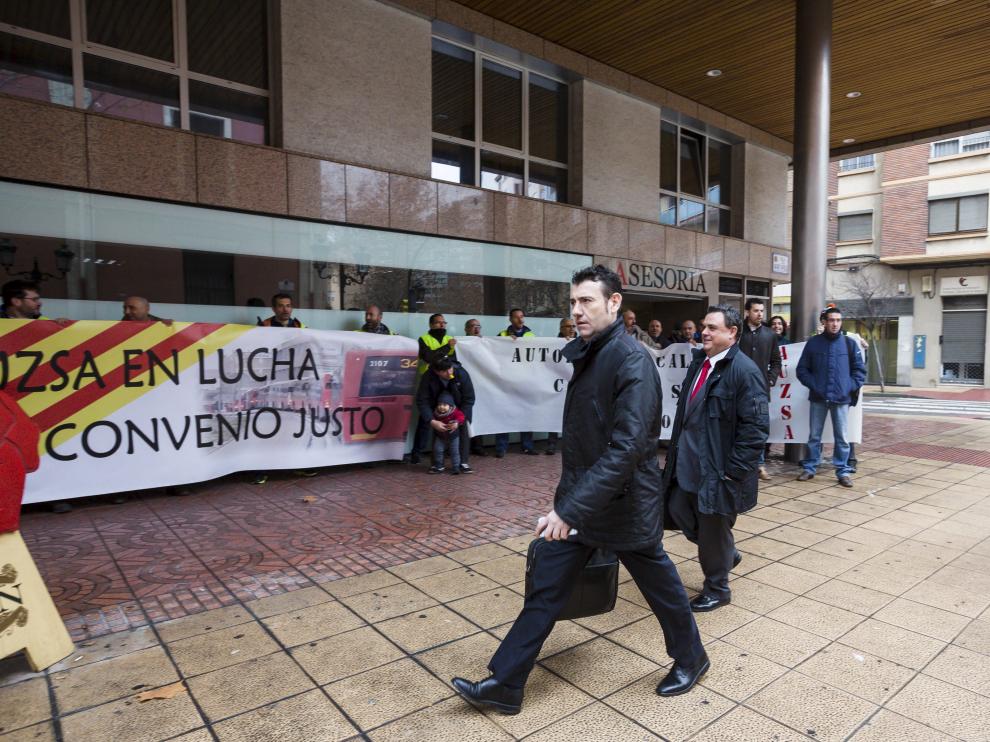 El gerente de Auzsa, Manuel Ramo, entra a la reunión en el servicio de Mediación entre pancartas de los trabajadores.