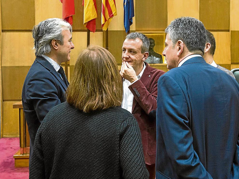 Jorge Azcón (PP) a la izquierda y Javier Trívez (PSOE) a la derecha, dialogan con Rivarés.
