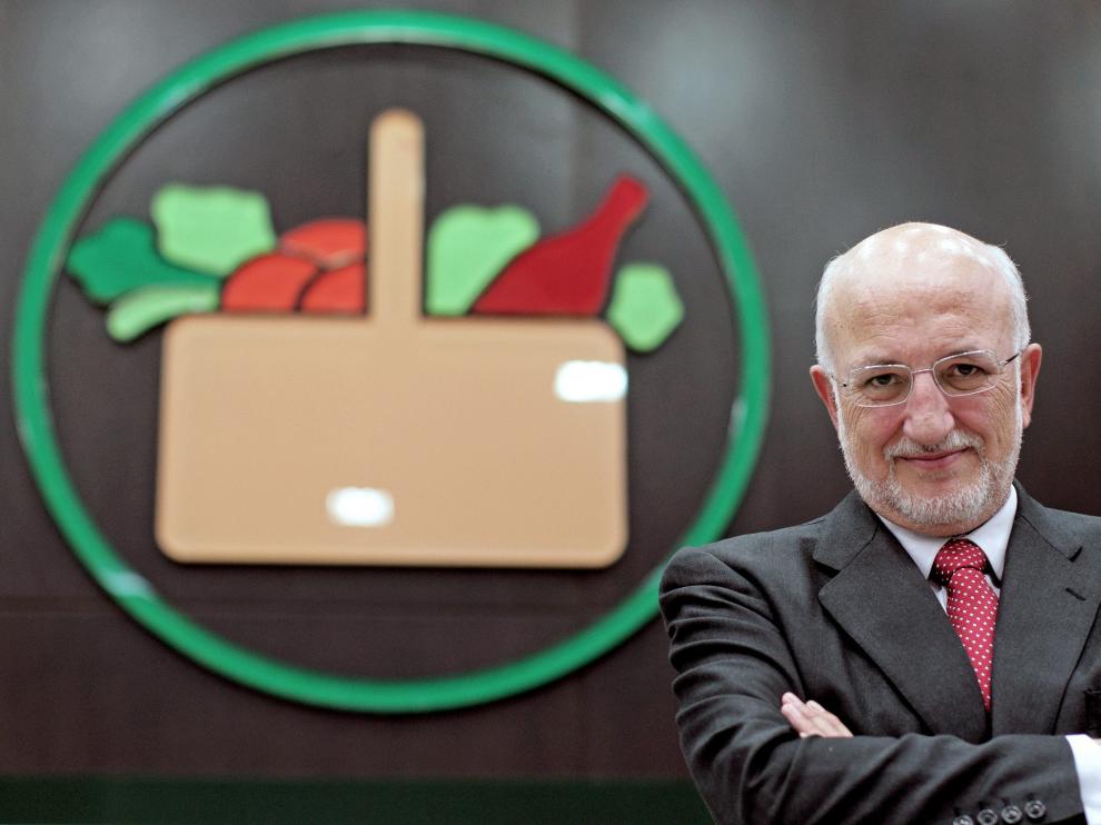 El presidente de Mercadona, Juan Roig, posa junto al logo del supermercado