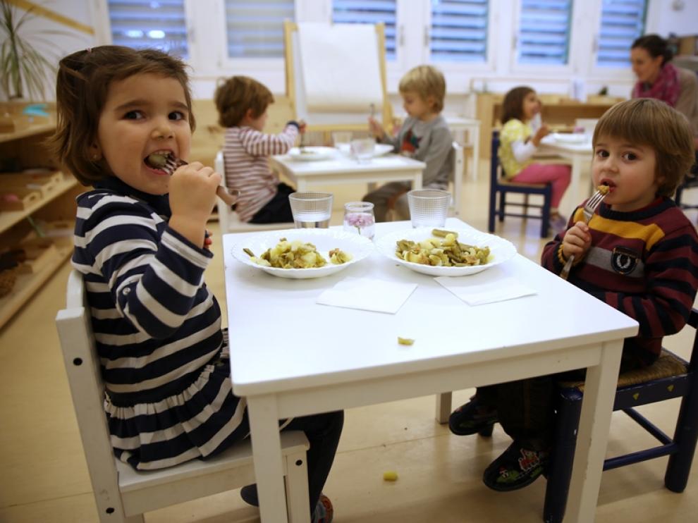 Los niños comen judía verde con patata y salteado de hamburguesa de espelta.