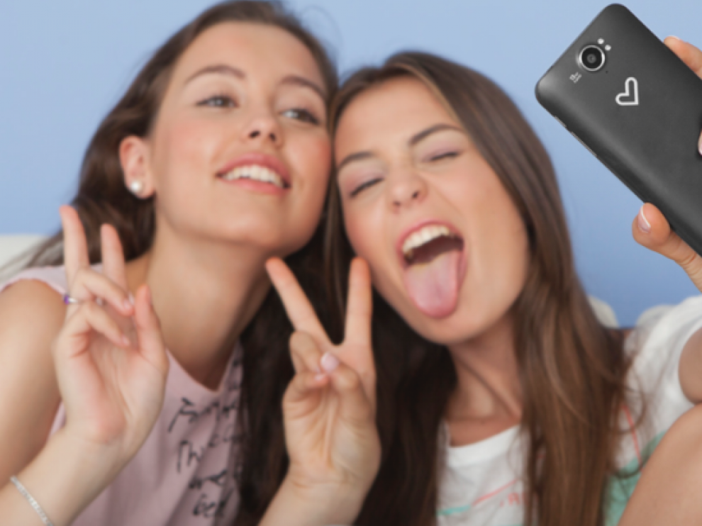 Dos jóvenes disfrutan haciendo un selfie.