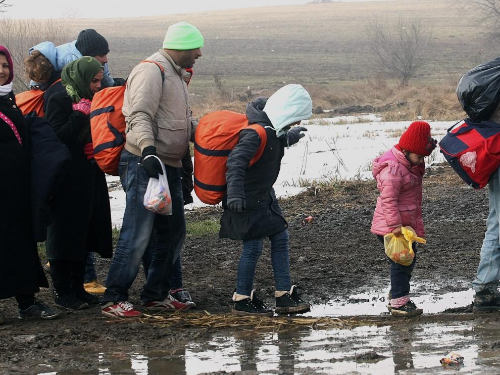 Refugiados se dirigen a un campamento temporal en Presevo (Serbia).