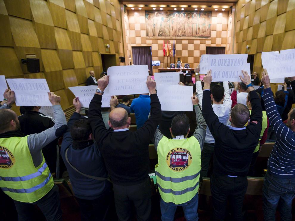 Trabajadores del comité de huelga de Auzsa muestran carteles reivindicativos durante el pleno de ayer.