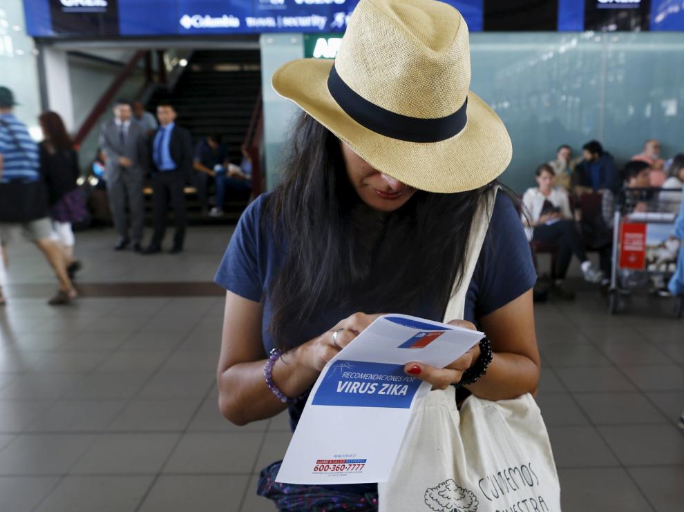Una turista con un manual sobre el virus Zika
