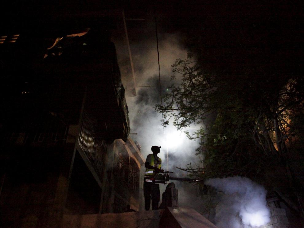 Un funcionario brasileño fumiga en la calles de un barrio de Brasil.