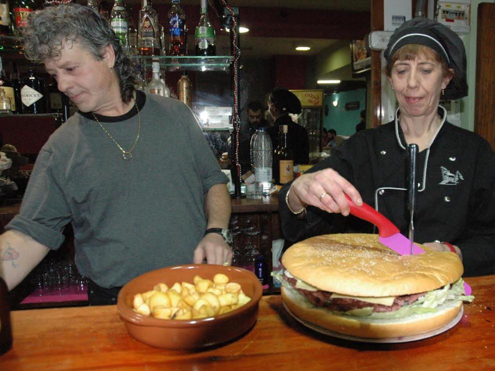 La hamburguesa objeto del reto, junto a la guarnición de papas bravas
