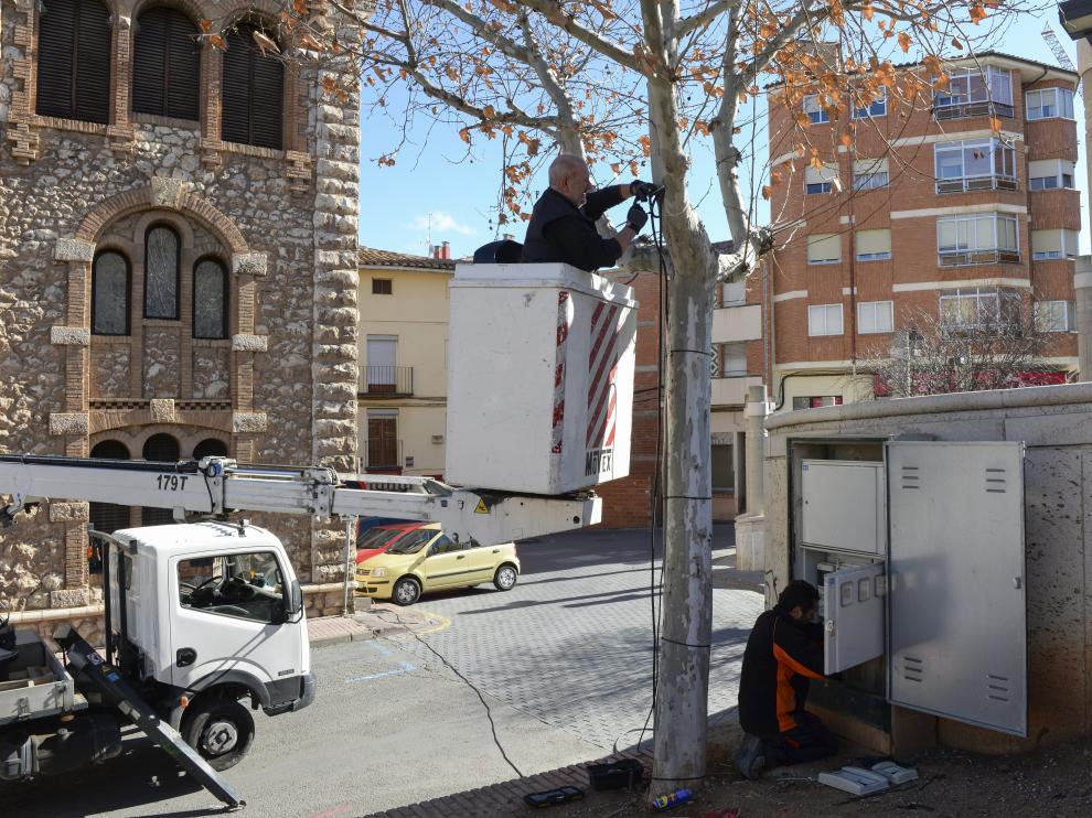 Unos operarios ultiman las instalaciones eléctricas en las zonas de las jaimas.