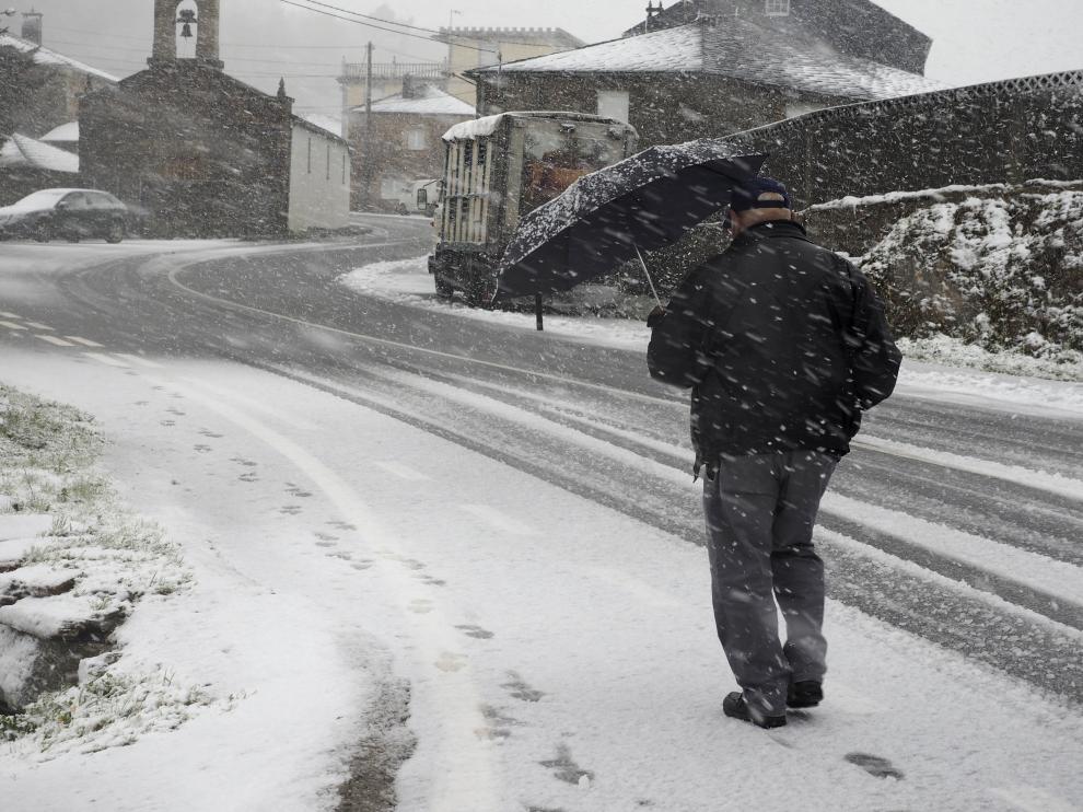 Un vencino de O Cádavo, en Lugo, se protege de la nieve.