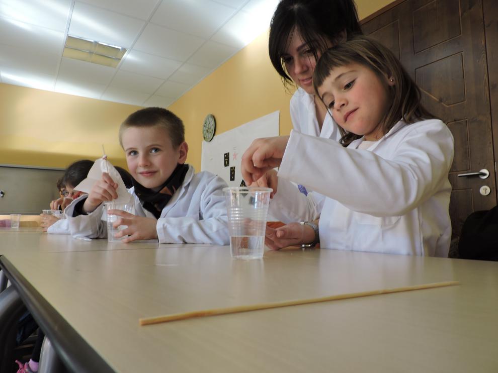 La monitora Ana Abás, con dos alumnos del taller de ciencia de Ibercaja Villahermosa durante la Semana Blanca.