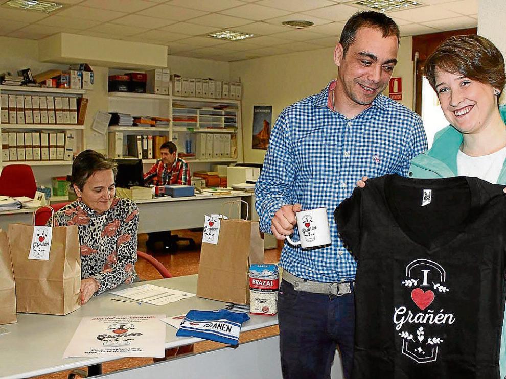 Marta Fiestas, junto al alcalde de Grañén, Carlos Sampériz, enseña la camiseta recibida al censarse.