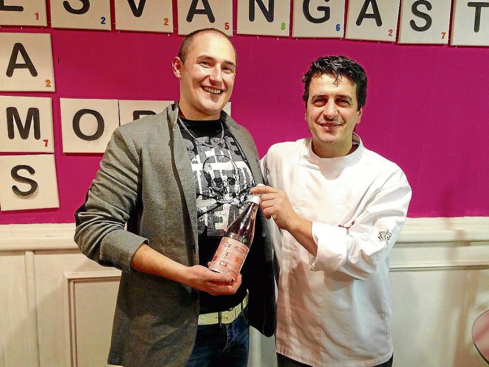 Los cocineros Carlos Martín y Roberto Baquero, con una botella de vino solidario de Care.