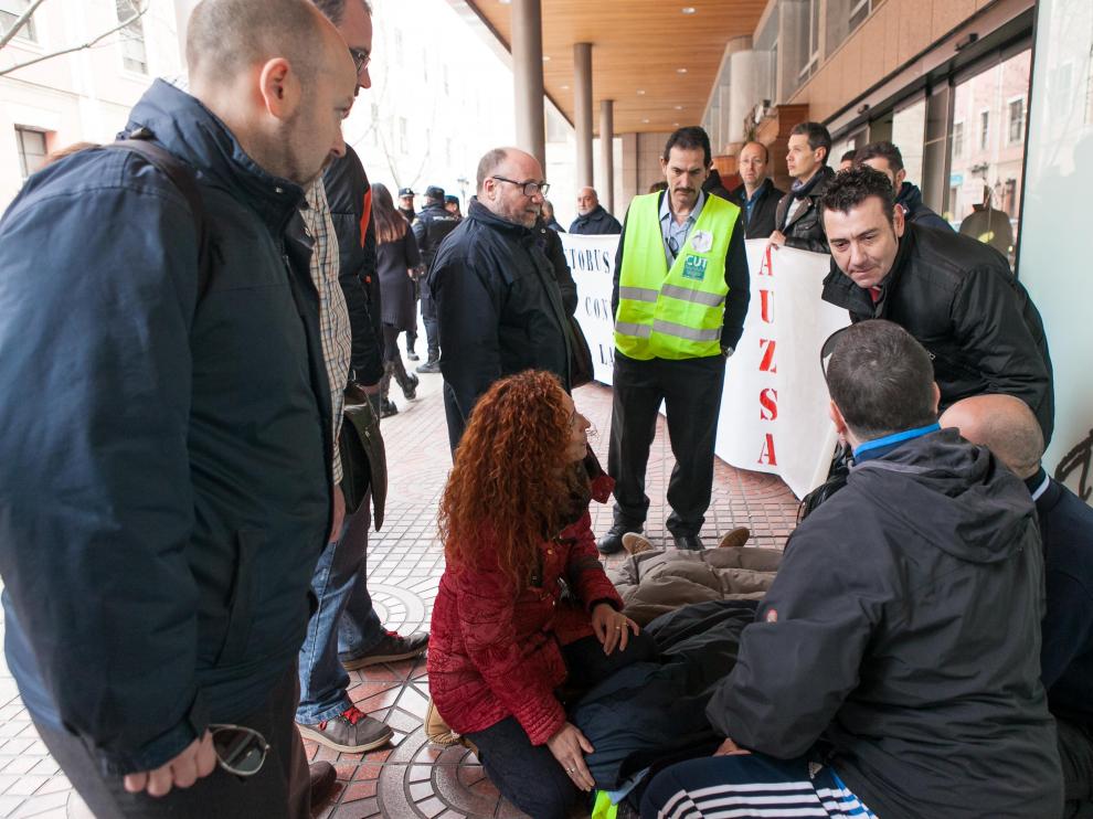 El gerente de Auzsa, Manuel Ramo -de pie, a la derecha- se interesa por el estado del conductor agredido, al que acompaña su mujer.