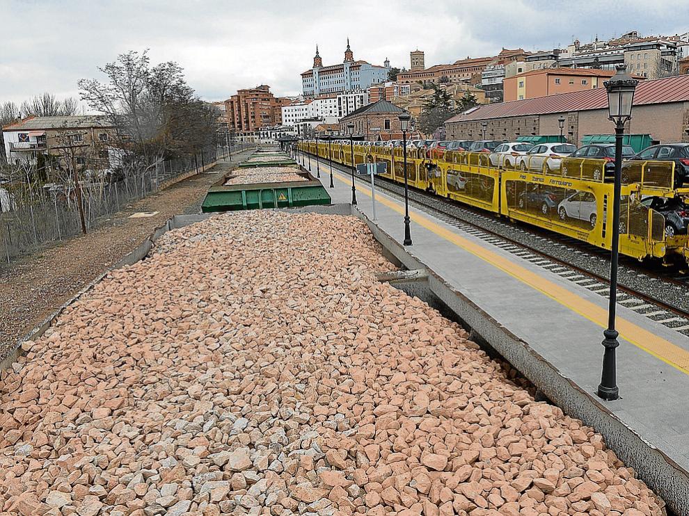 El nuevo tren, cargado de balasto, ayer junto al convoy de coches de la Opel de General Motors.
