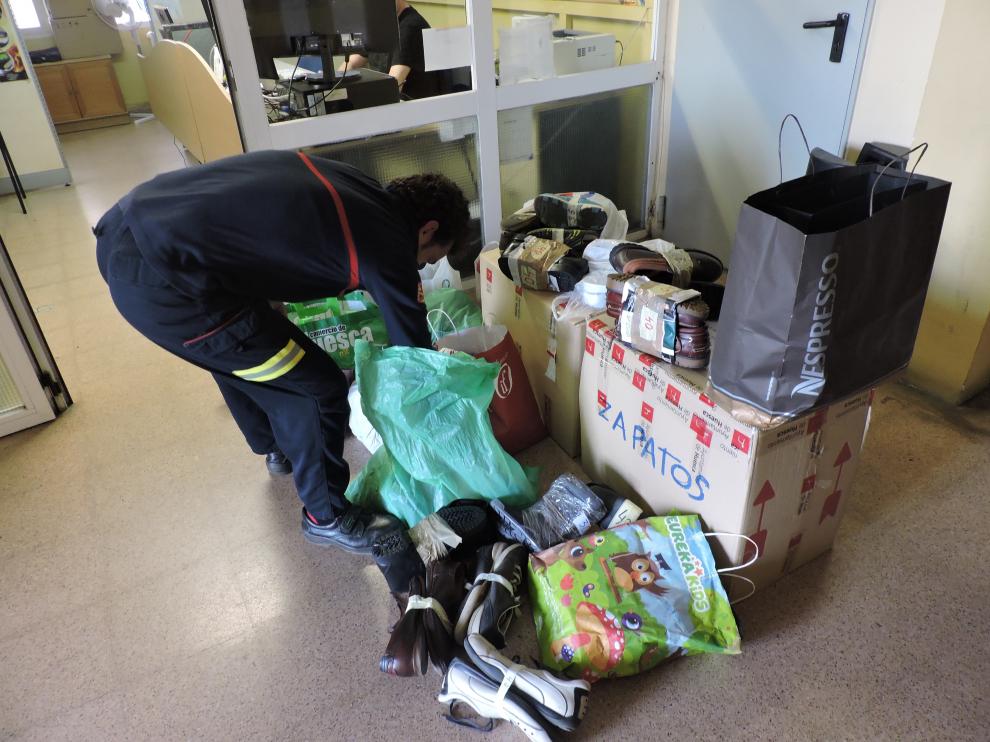 Un bombero clasificando zapatos de la campaña 'Descálzate por Lesbos'.