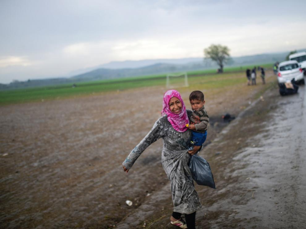 Una mujer refugiada camina en las afueras del campo de Idomeni, en Grecia