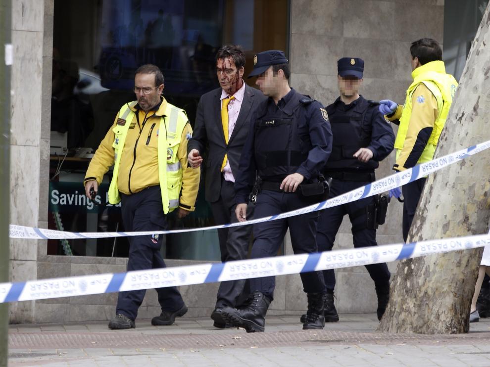 Policía y miembros del Samur acompañan al hombre herido tras sorprender a dos ladrones robando en una vivienda de Madrid.