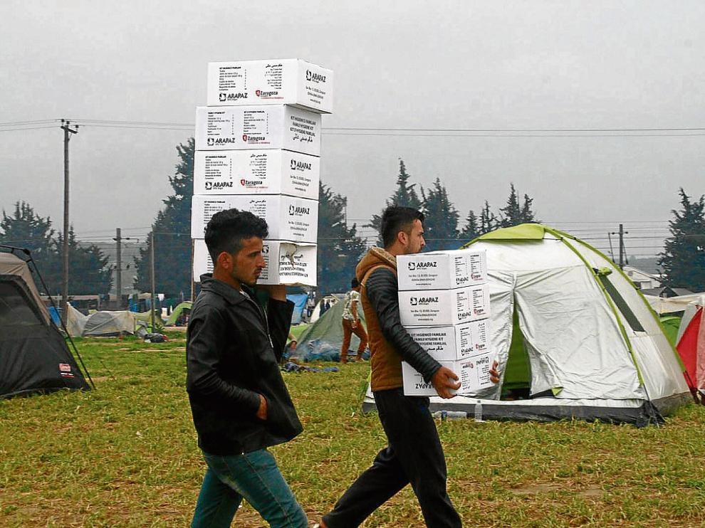 Dos refugiados del campo de Idomeni, entre Grecia y Macedonia, con ayuda de Arapaz.