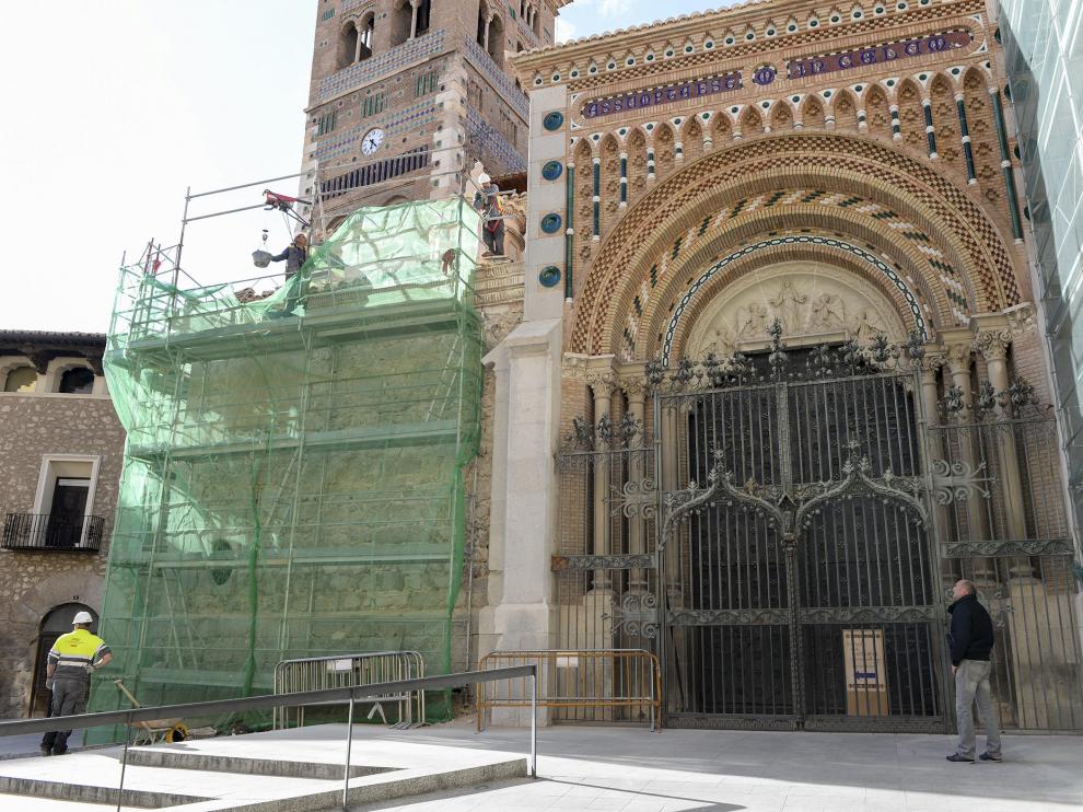 La verja del pórtico de la catedral, en medio de los andamios de las fachadas.