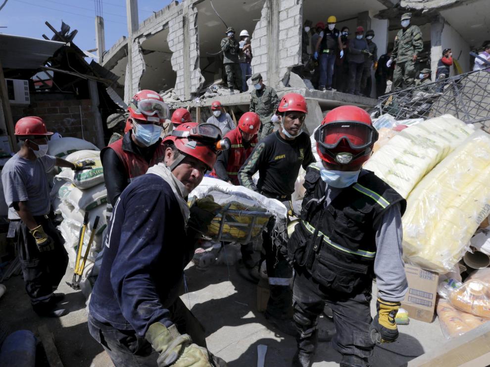 Miembros de los equipos de rescate trasladan a una víctima rescatada entre los escombros en Pedernales, Ecuador.
