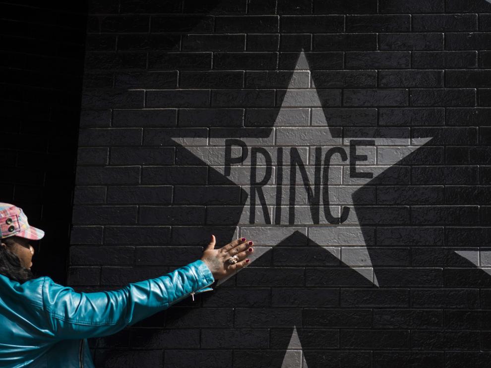 Una admiradora de Prince, ante un cartel con el nombre del artista.
