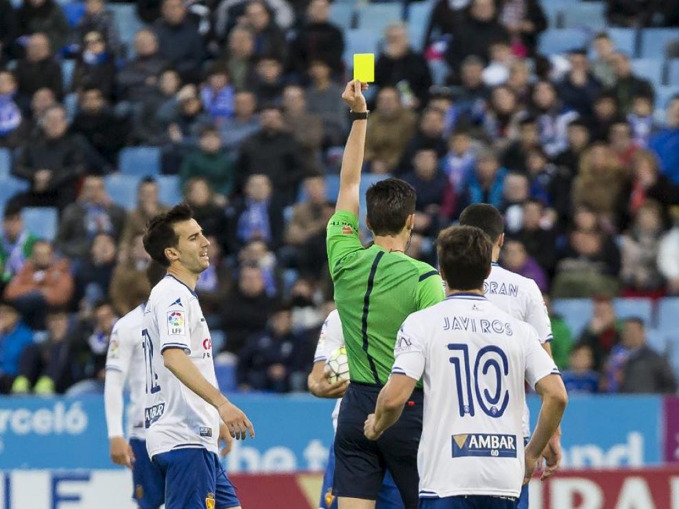 Munuera Montero, el arbitro jiennense del choque ante el Alcorcón, muestra la tarjeta amarilla a Lanzarote.